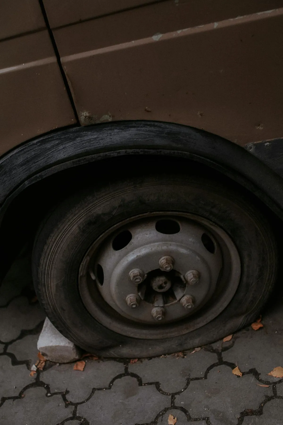 A flat car tyre at the roadside with no spare wheel available