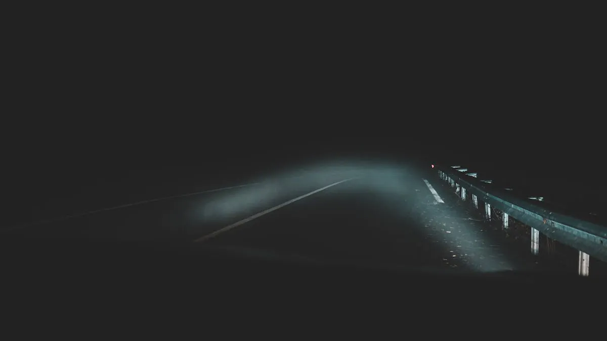 A car driving at night on a dark road with headlights on
