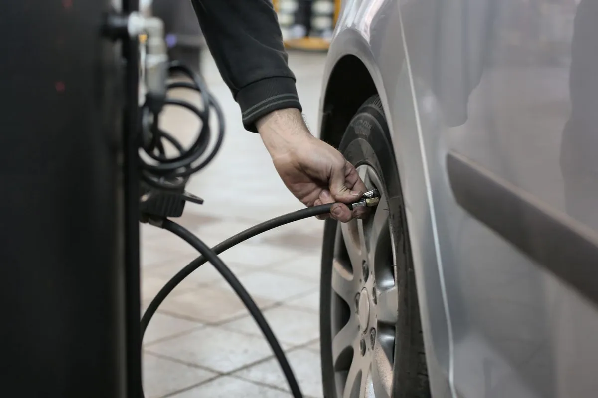 A fitter removing a seized locking wheel nut from a car wheel