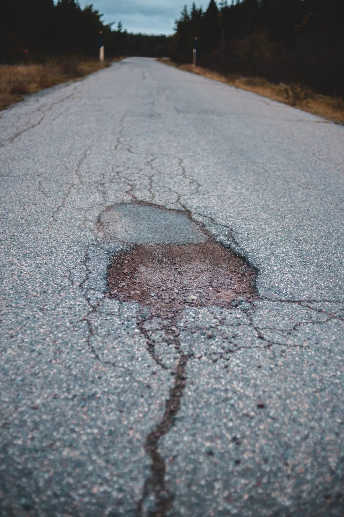 A pothole in a wet road that can damage car tyres and wheels