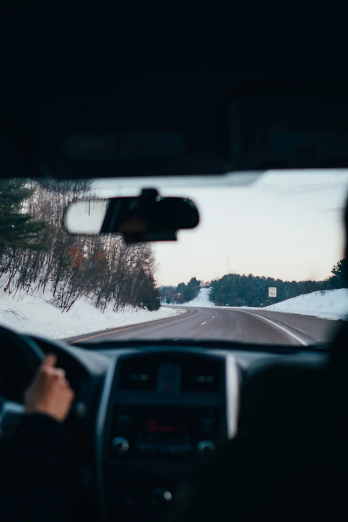 A snow-covered road with tyre tracks