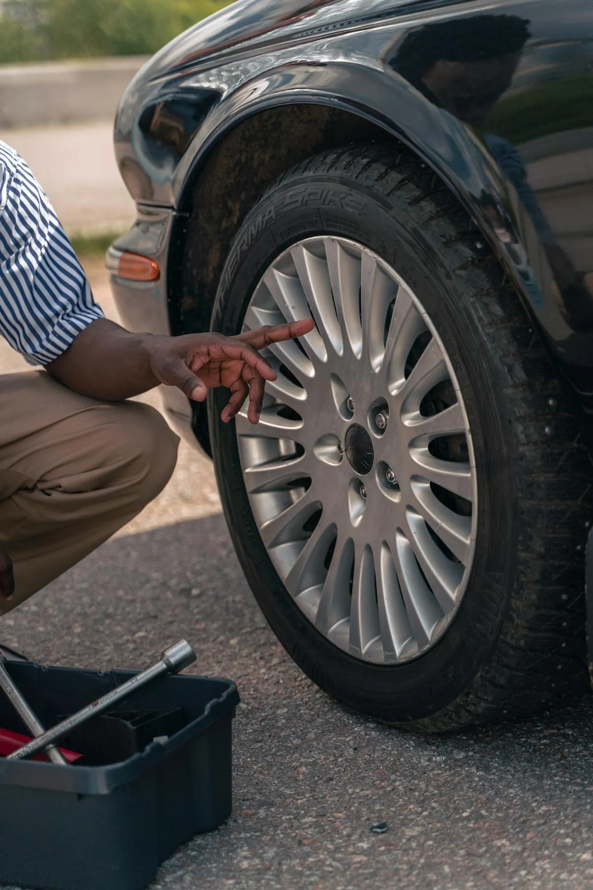 A mechanic inspecting a car tyre during an MOT test